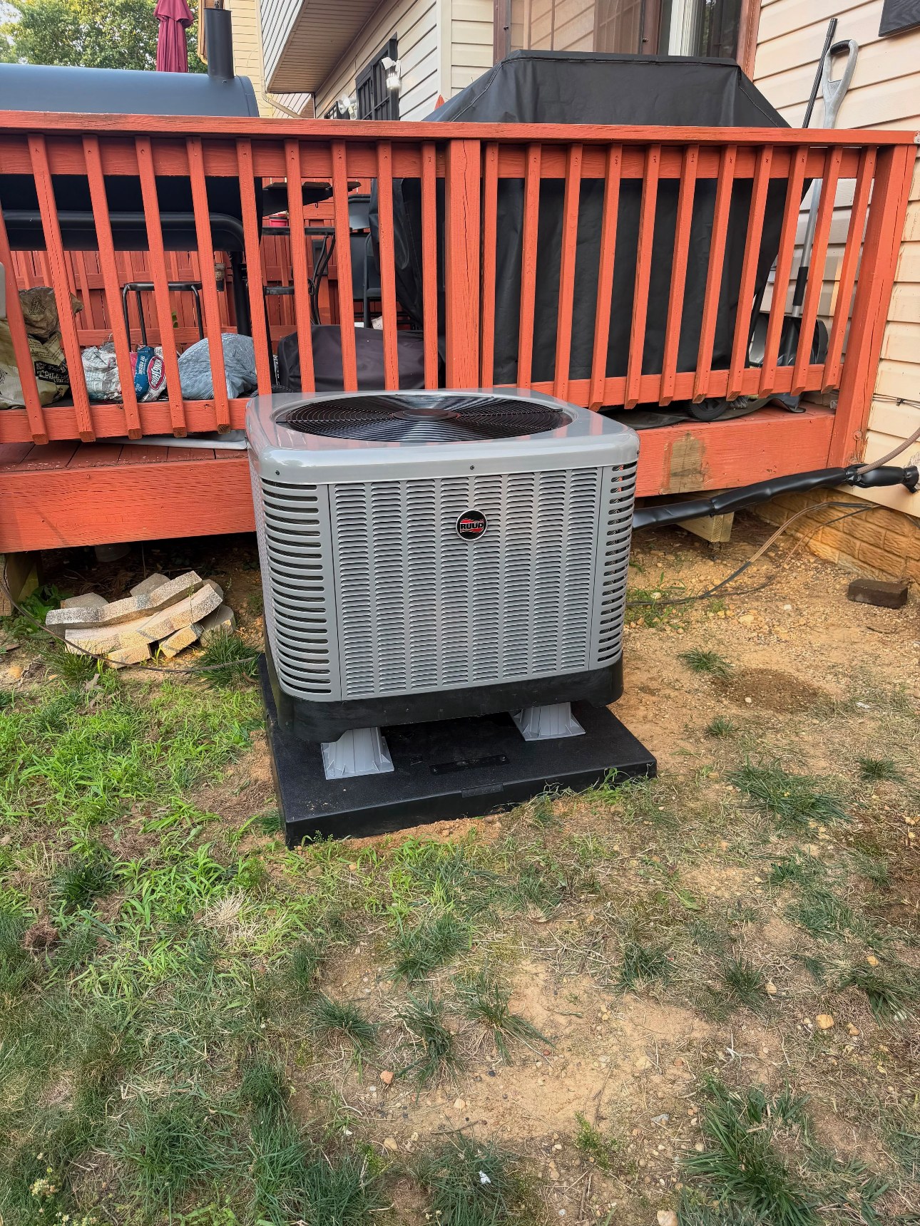 New Ruud outdoor condenser installed beside a deck after replacement